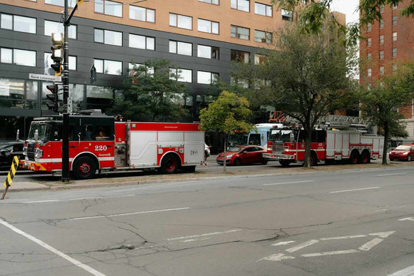 fire trucks in traffic on busy street in downtown Montreal